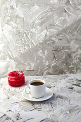 A white cup of coffee on a grey background. Hot drink concept. Coffee shop, espresso, copy space