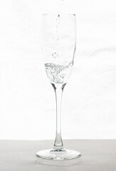 Filling up the champagne glass water  isolated on a white background