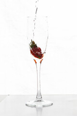 Filling up the champagne glass with strawberry isolated on a white background copy space