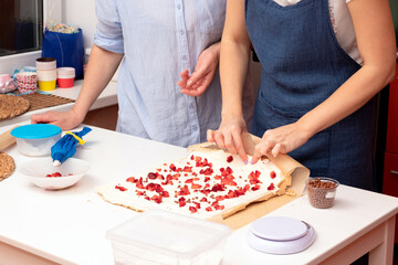 The process of making a meringue roll with cream and strawberries. Selective focus.