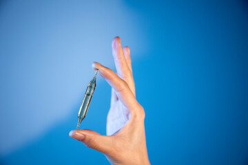 main qui tient une ampoule de vitamines