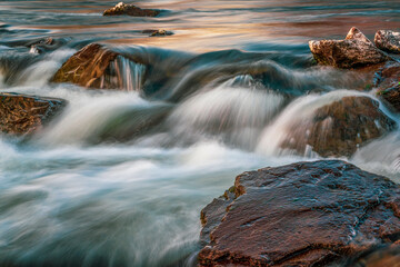 Long exposure of a river at sunset .