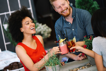 Group of diverse friends talking and having fun at cafe outdoor