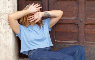 Young woman hide her face with hands