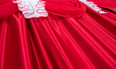Close up of red and white color lambrequin and curtains, silk texture with folds, fabric background