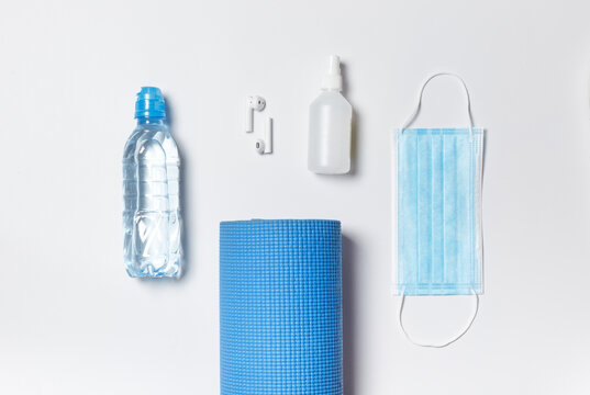 Rectangular layout. Preparing for exercise, yoga Mat, water bottle, headphones, protective, mask and sanitizer