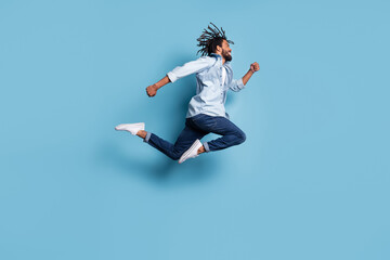 Fototapeta na wymiar Full body profile photo of energetic dark skin person running hurry fast isolated on blue color background