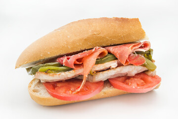 Sandwich Serranito typical in Andalusia with ham, green pepper and grilled pork loin