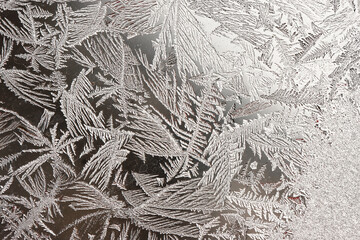 Frozen winter abstract background with a pattern on the window glass