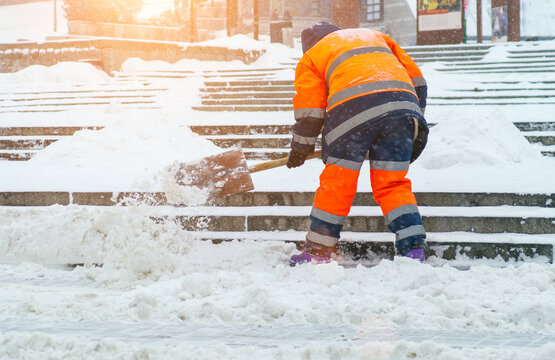 Snow removal. A worker cleans snow with a shovel after a snowfall at gatherings