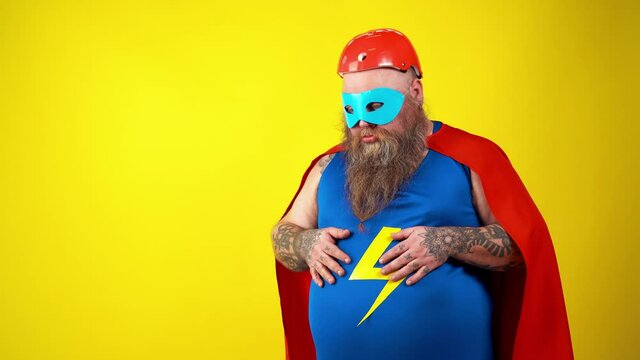 Chubby super hero in action. Masked hipster man on colored background