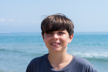 Portrait of a smiling male teen against blue sea