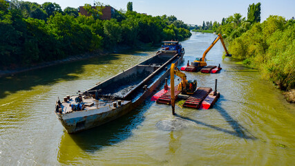 Aerial view of river, canal is being dredged by excavators