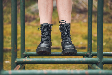 Person with boots on park swing