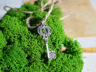 One old key lies on the moss on the background of an old map, the key to treasure, travel and adventure