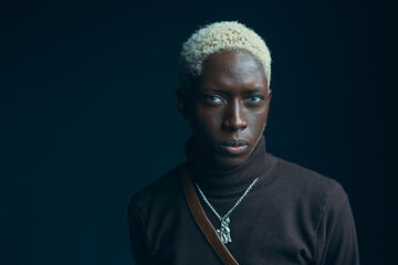 portrait of a dark-skinned handsome guy with white hair and blue eyes, who looks into the camera...