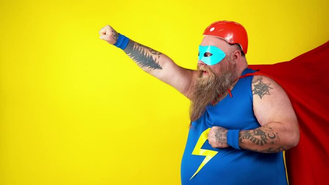 Chubby super hero in action. Masked hipster man on colored background