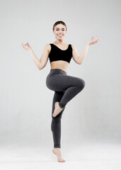 Portrait of beautiful young woman wearing sportswear working out in studio. Fit sporty girl doing...