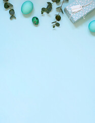 Easter celebration concept frame on the blue background with gifts and painted eggs. Copy space	