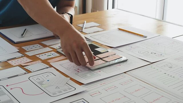 UX or UI designer designing application on tablet with mockup layout prototype.