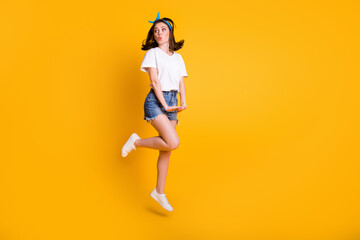 Fototapeta na wymiar Full length body size photo of young woman jumping looking at blank space whistling isolated on vibrant yellow color background