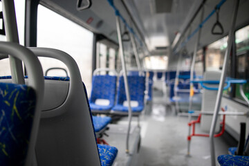 Naklejka premium Empty bus interior. Blue seats without passengers. Public transport. Transportation of passengers by public transport. Ergonomic interior of the bus. Travel to other cities.