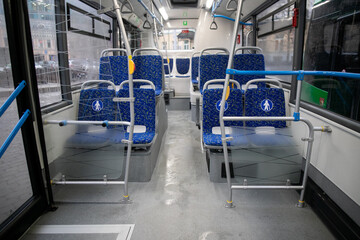 Empty bus interior. Blue seats without passengers. Public transport. Transportation of passengers by public transport. Ergonomic interior of the bus. Travel to other cities. © Семен Саливанчук