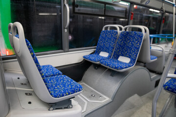 Empty bus interior. Blue seats without passengers. Public transport. Transportation of passengers by public transport. Ergonomic interior of the bus. Travel to other cities.