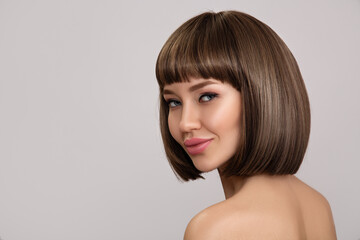 Beautiful brunette woman with bob hairstyle. smooth shiny hair with bangs