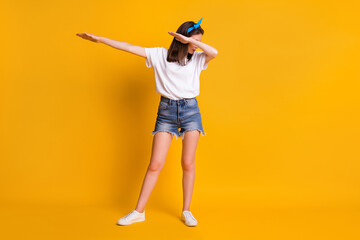 Full length body size view of pretty skinny funky girl having fun moving dab clubbing isolated over vivid yellow color background