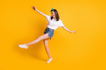 Fototapeta na wymiar Full length body size view of pretty skinny cheerful brown-haired girl jumping having fun isolated over bright yellow color background