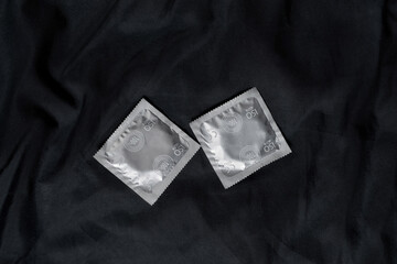 Preventing sexually transmitted infections. Condoms on the black cloth