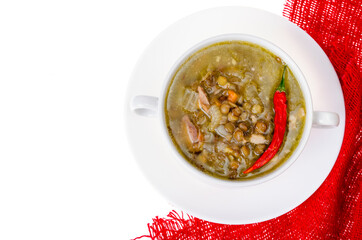 Spicy green lentil chili soup on white plate.