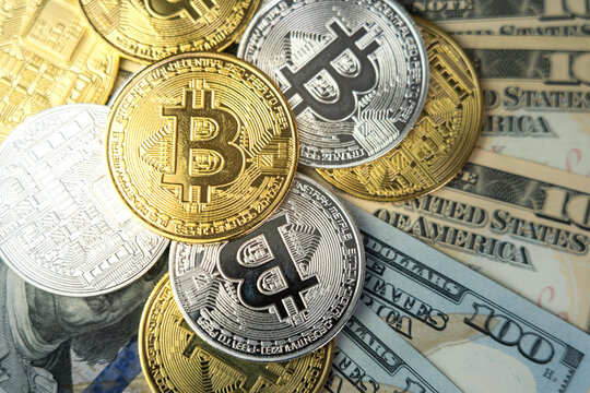 Bitcoin coins (btc, xbt) both in golden and silver metallic color placed on the US dollar banknote. Money transformation to digital currency concept, selective focus at the some coin object photo.