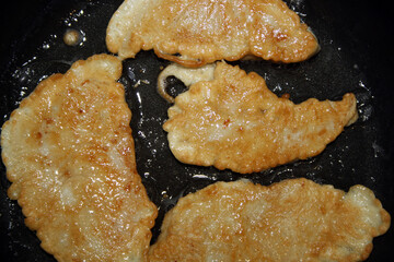 Chicken fillet in batter in a pan.