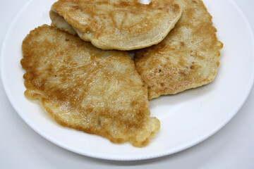 Chicken fillet in batter on a white plate.