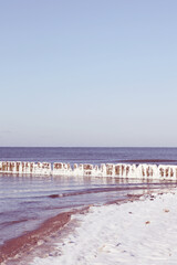 beach at winter with breakwater in ice