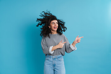 Excited beautiful girl smiling and pointing fingers aside