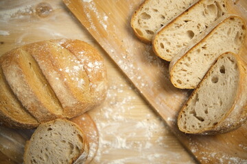 Bread sliced and freshly baked on a wooden table. Flour, bakery. The cooking process is captured in 4k resolution. Selective Focus