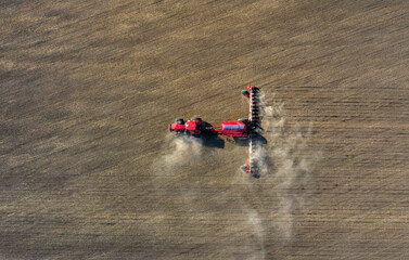 A farmer in a tractor prepares land with a sowing cultivator as part of pre-sowing work at the...