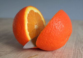 orange fruit cut by knife on wooden table
