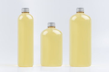 Collection plastic transparent bottles - tall, low and thick with orange drink, cooking oil or cosmetic produce, silver cap mockup on white background, template.