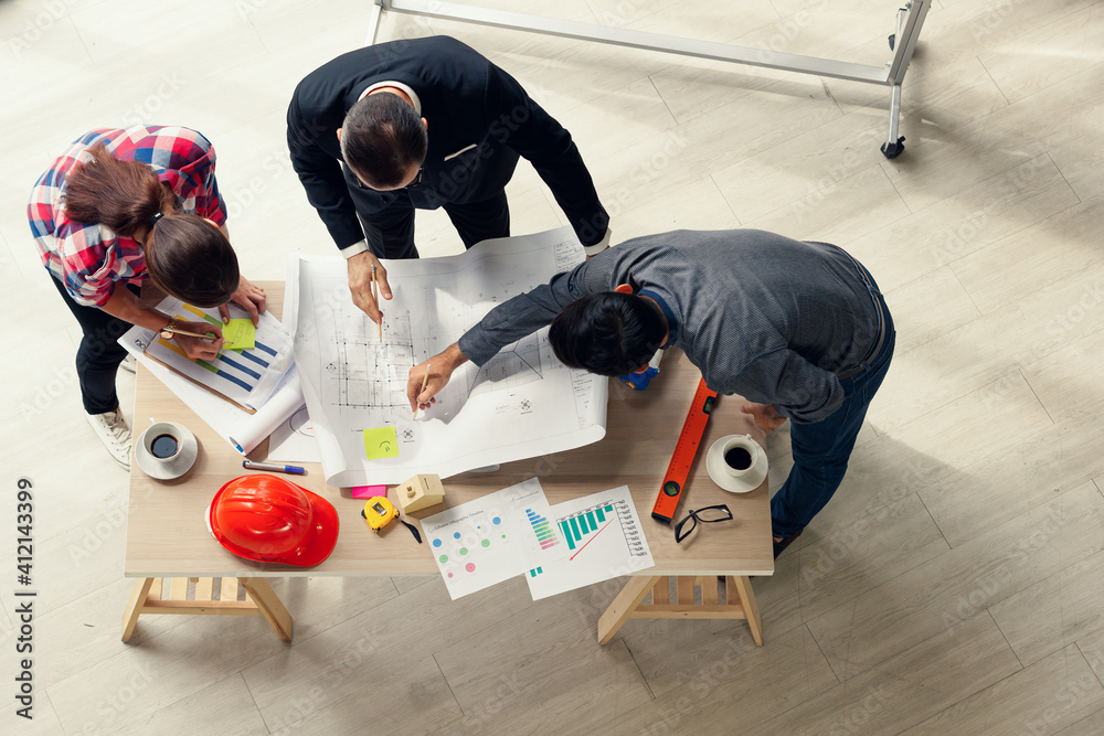 Poster group of engineers and boss in a formal suit working and brainstorming in construction office, taken