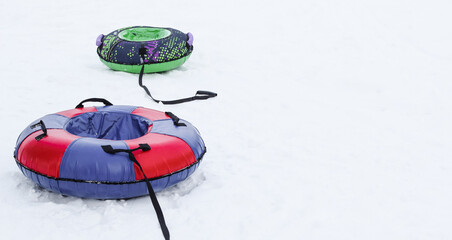 Two snow tubing for active winter holidays. Games for children's holidays and weekends. Copy space.