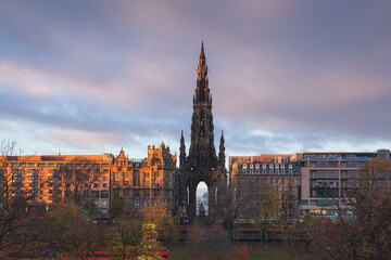 View of the Sir Walter Scott Monument and new town cityscape skyline from Old Town Edinburgh overlooking Princes Street Gardens with colourful clouds at sunset or sunrise.