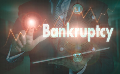 A businessman operating a computer display with a Bankruptcy business word concept on it.