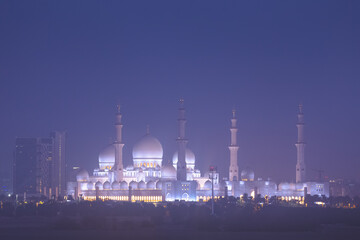 Fototapeta na wymiar Exterior view at night of illuminated Sheikh Zayed Grand Mosque in Abu Dhabi, UAE.