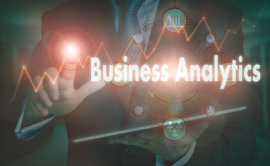 A businessman operating a computer display with a Business Analytics business word concept on it.