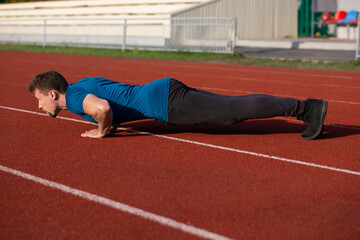 Athlete guy in sport clothes doing push ups
