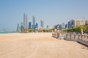 An empty view with no people down the sandy Corniche Beach and promenade with cityscape skyline of...